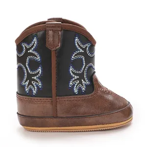 Vue détaillée de bottes de cowboy pour bébé en marron et noir avec broderie bleue.