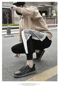 Detailed side profile of men's black genuine leather work shoes on an asphalt road
