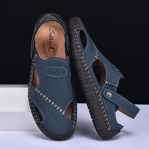 Detailed view of navy leather men's sandals with prominent hand-stitched detailing.