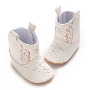 Detail of white baby cowboy boots with colorful embroidery and soft non-slip sole.