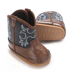 Gros plan sur des bottes de cowboy pour bébé fille en similicuir marron avec semelle antidérapante