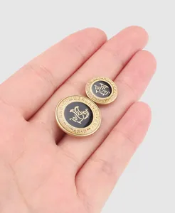 Detailansicht von Vintage-Messingknöpfen mit schwarzer Emaille und Goldgravur.