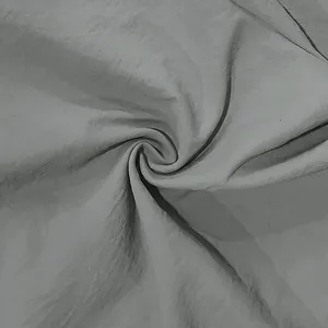 Macro view of light gray linen fabric texture showing soft folds and durable weave