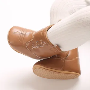 Detail shot of brown infant cowboy boots featuring soft PU leather and anti-slip sole