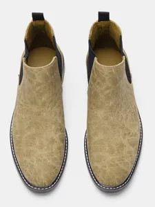 Vue de dessus de bottines Chelsea en cuir pour hommes avec texture vintage et design sans lacets.