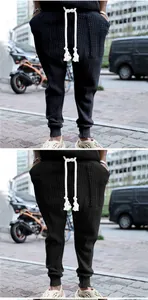 Close-up detail of black textured jacquard knit joggers with a thick white drawstring tie