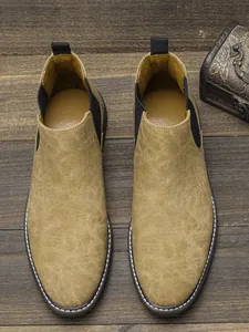 Vue de dessus en gros plan de bottines Chelsea pour hommes sur fond de bois vintage