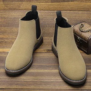 Gros plan de bottines Chelsea en daim beige pour hommes sur fond de bois vintage