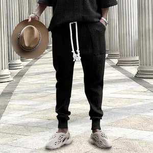 Stylish men's black knitted drawstring pants featuring a unique textured jacquard pattern