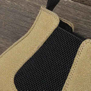 Gros plan sur la texture du daim sable et le gousset élastique d'une botte Chelsea pour homme.