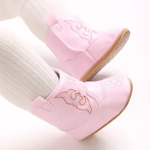 Close-up of pink soft baby girl boots with decorative stitching for indoor walking