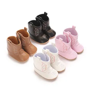 Detaillierte Ansicht von vier Paar Baby-Cowboystiefeln in Braun, Schwarz, Rosa und Weiß.
