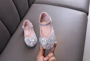 Detailed view of the sparkling rhinestone bow on elegant pink girl's princess shoes