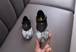 Detailed view of sparkling rhinestones and butterfly bow on girl's princess dance shoe