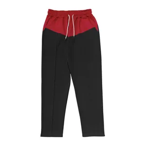 Detailed view of men's red and black color-blocked casual pants with straight leg fit