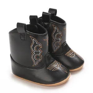 Close-up of stylish black baby girl cowboy boots with detailed decorative embroidery