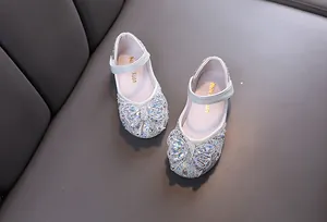 Detail of girls' silver princess shoes with sparkling rhinestone butterfly knot