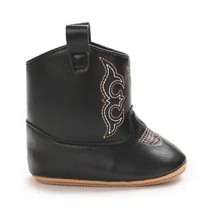 Macro detail of black western style baby boots featuring contrast stitching accents