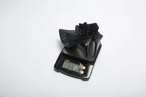 Black mesh stiletto bootie with rhinestones on a digital scale weighing 332g