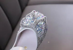 Detailed macro view of sparkling rhinestone butterfly decoration on white girl's princess shoes