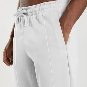 Close-up of men's white drawstring sweatpants showing pocket detail and knit texture.