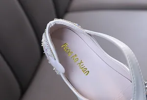 Close-up detail of white girl's princess shoe showing sparkling rhinestone embellishments