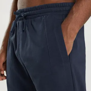 Close-up of navy blue men's joggers showing drawstring waistband and side pocket detail