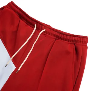 Detail of men's oversize color-block pants featuring drawstring waist and pockets.