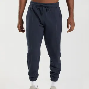 Front view detail of navy men's joggers with vertical seam lines and drawstring waistband.