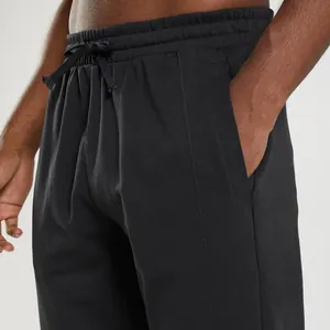 Detail shot of men's black knit sweatpants with drawstring waist and side pocket