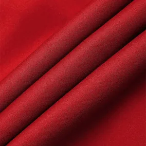 Macro view showing the dense woven texture of the red fabric used in men's trousers
