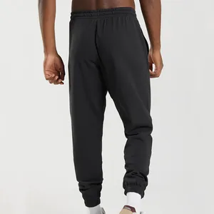 Back view of men's black knit jogger sweatpants with loose fit and elastic cuffs.