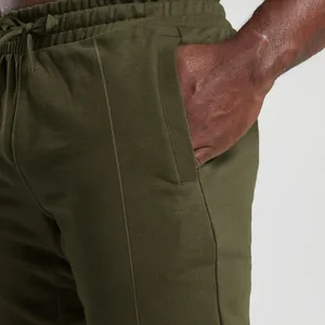 Detail view of olive green men's knit joggers showing pocket and waistband