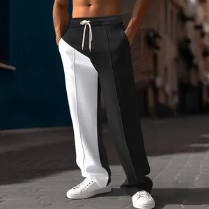 Detail of men's black and white color-block casual wide-leg trousers with loose fit.