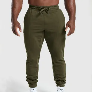Detailed view of olive green men's athletic joggers with drawstring and cuffed ankles