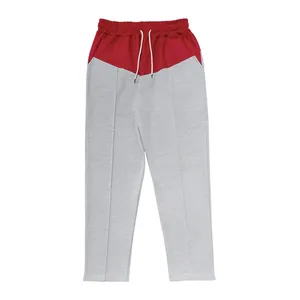 Detailed view of men's oversize straight-leg sweatpants in red and grey color block
