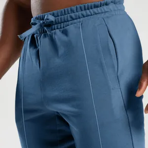 Close-up detail of blue men's joggers showing drawstring waist and side pocket design.