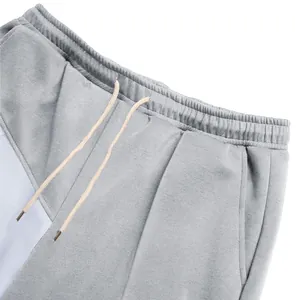 Detail view of men's gray and white color-block drawstring waist casual pants.