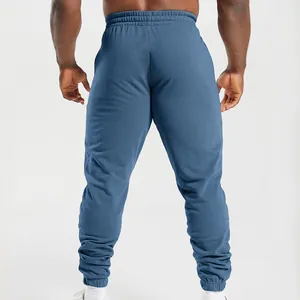 Rear view of blue men's knitted joggers with elastic waist and cuffed ankles for sports