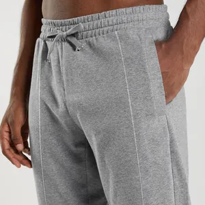 Detailed close-up of grey men's joggers showing drawstring waist and side pockets