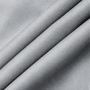 Close-up of the fine woven texture and draping of the grey casual pants fabric.