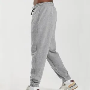 Side profile detail of men's grey knit joggers with elastic waist and cuffed hem.