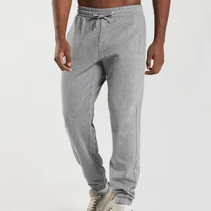 Close-up of grey men's joggers featuring elastic drawstring waist and cuffed ankles.