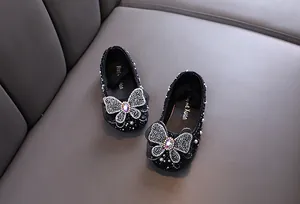 Détail de chaussures de princesse noires pour filles avec strass et nœuds papillons élégants