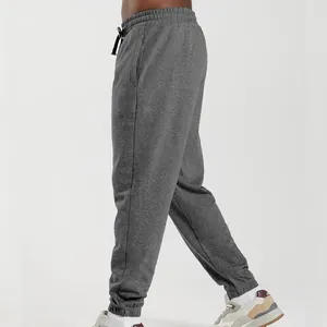 Side view detail of grey heather knitted sweatpants for men with elasticated cuffs.
