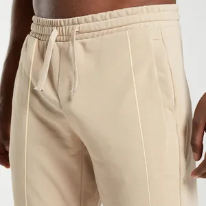 Detail view of beige men's sports sweatpants showing drawstring waist and premium fabric