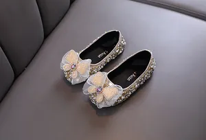 Gros plan de chaussures de princesse pour fille avec perles, strass et nœud en dentelle