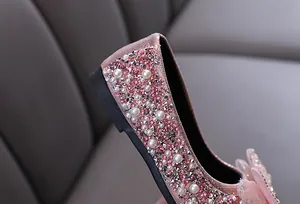 Détail des chaussures de princesse roses pour filles avec strass brillants et perles décoratives