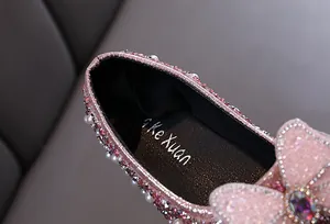 Gros plan de chaussures de princesse roses avec strass étincelants et détails perlés.