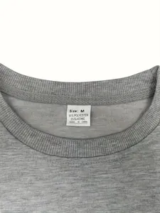 Détail de l'encolure d'un t-shirt gris avec étiquette 95% polyester, taille M